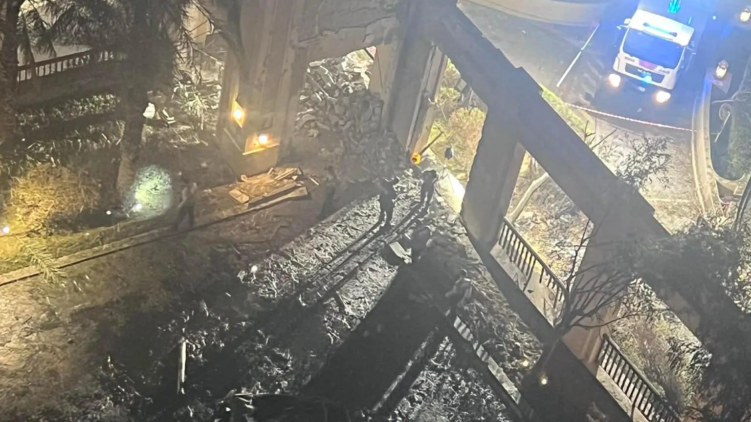 Simon Rourke The picture shows rubble and damage following an explosion outside the hotel. The wreckage is blackened in the foreground and an emergency vehicle with its blue lights flashing can be seen in the background.