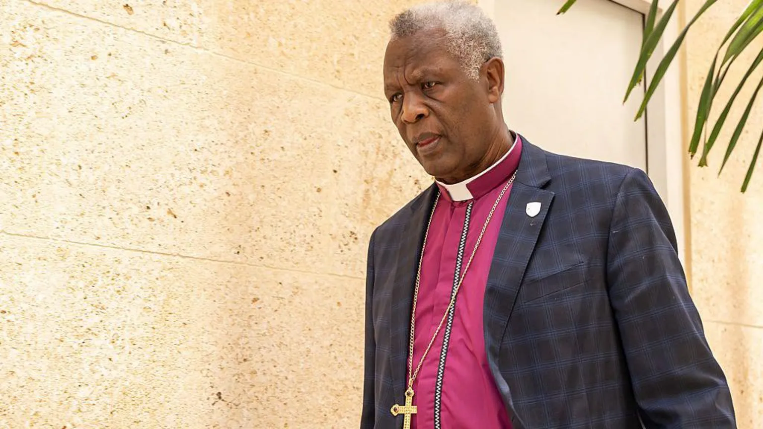AFP via Laurent Mbanda, wearing a purple shirt and blue jacket with a chain around his neck with a golden cross pendant