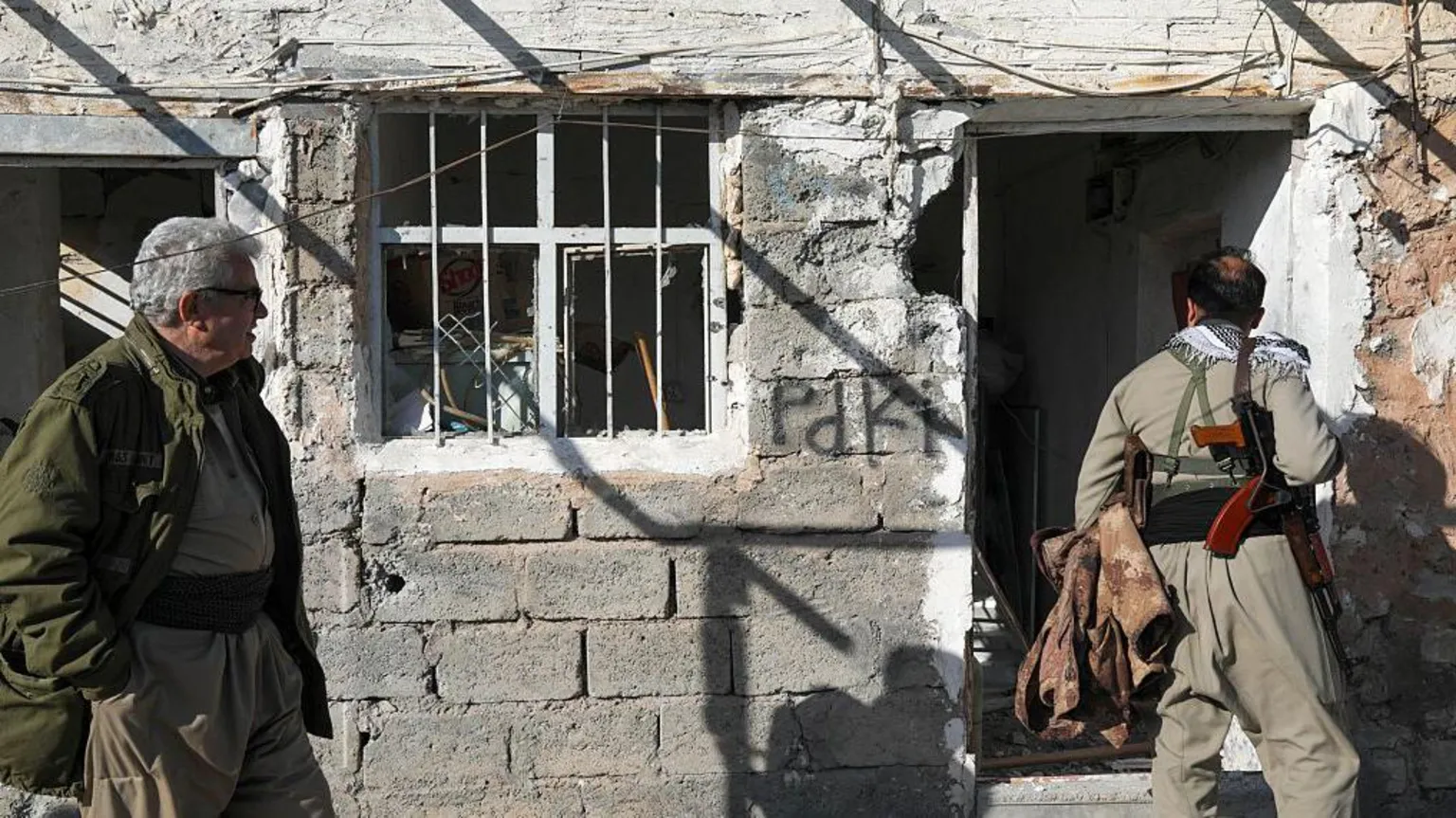  Men inspect damage to the Azadi Camp of the Kurdistan Democratic Party of Iran