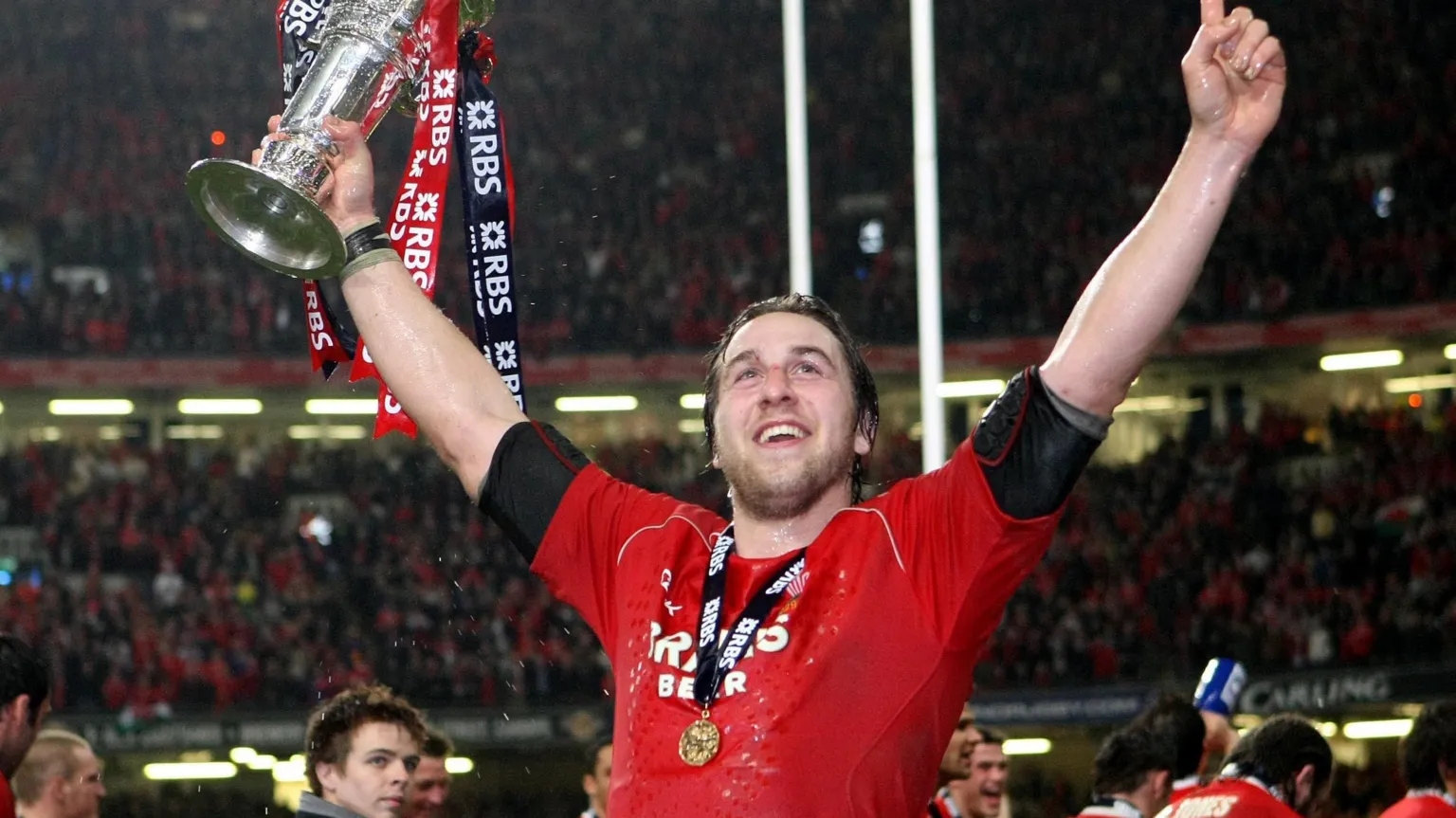  Former player Ryan Jones celebrating with a red Wales shirt and a medal around his neck