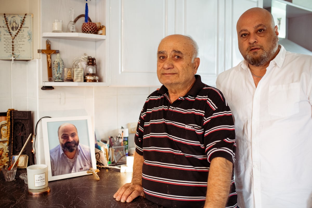 Eddie Pampalian and his father, Chris, stand by a framed photo of Steve.