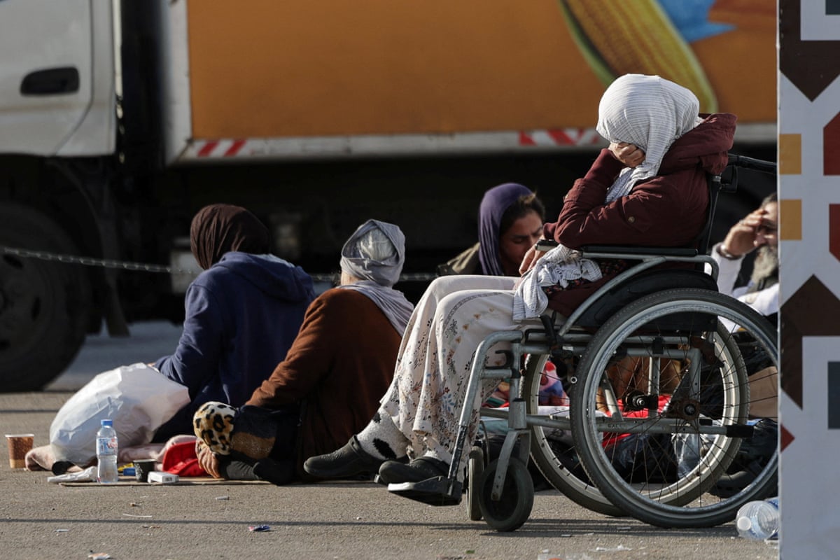 Four people including one in a wheelchair sat outside in Matyrs' Square in Beirut.
