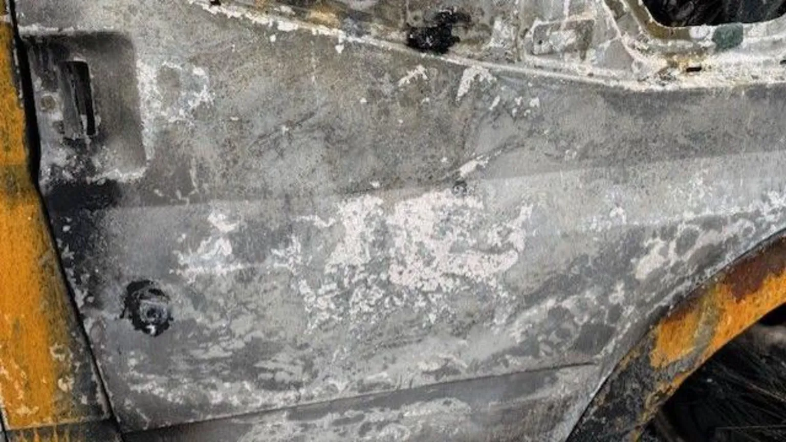 St Joseph's R.C. Primary School A close up image of the side of the bus that has been torched. There is a patch that has the outline of a dragon, the school's logo, in white.