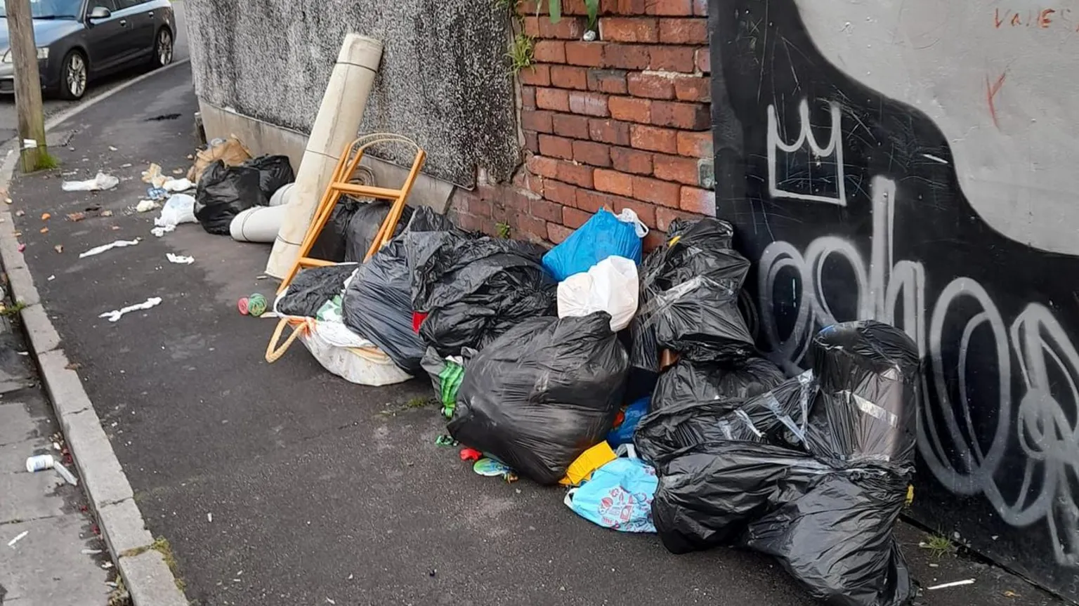 David Wall Black bags and household items are dumped on the street 