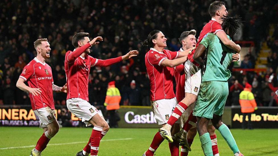 Wrexham players celebrate with Arthur Oknonkwo