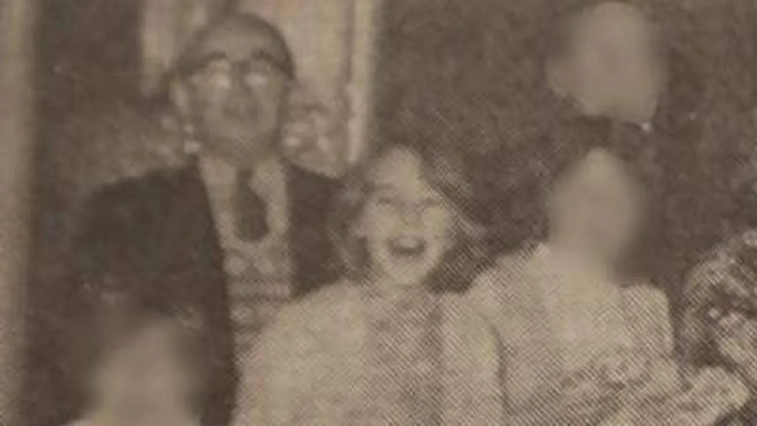 Black and white photograph. On the left is William Barrie who is bald and wearing glasses, tie, jumper and blazer. On the right is Mary with a bob. 