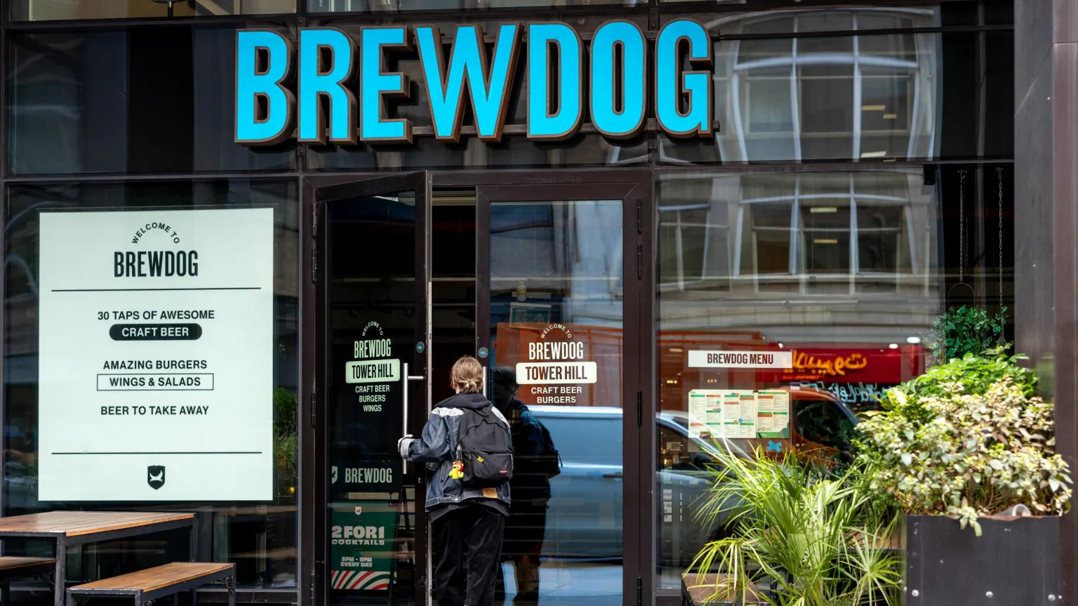  A person entering a Brewdog bar in Tower Hill, London.