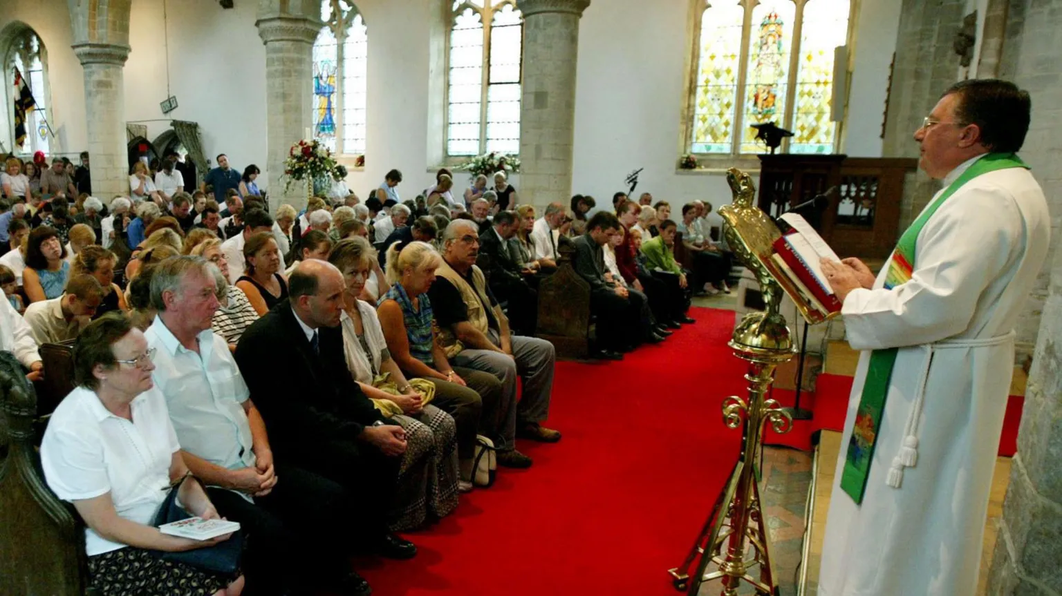  A church minister leads a service in front of a packed congregation.