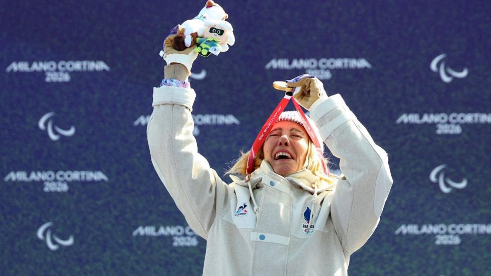 Cecile Hernandez lifts up her Paralympic gold medal on the podium
