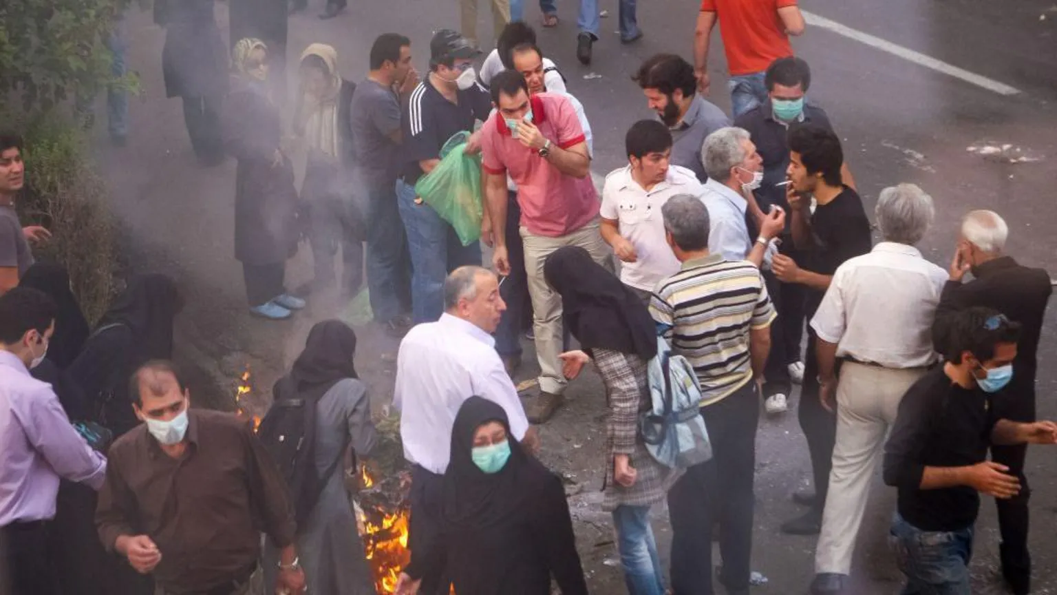  Protesters gathering during the 2009 protest, with some individuals blowing smoke into each other's eyes to lessen the impact of tear gas.