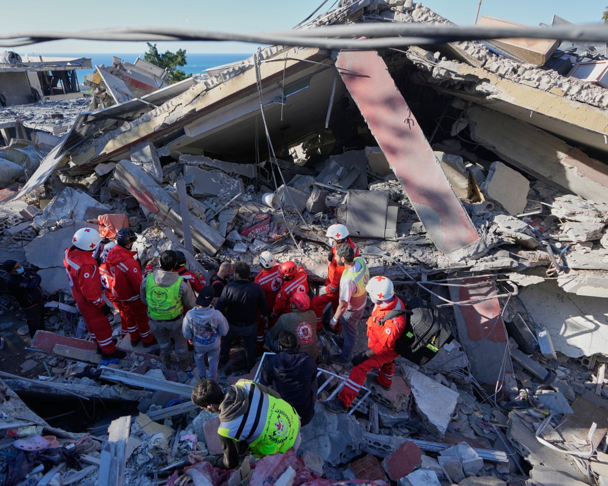 Rescue workers search for victims at a destroyed building hit by an Israeli airstrike in Ghaziyeh town, south Lebanon, on Sunday