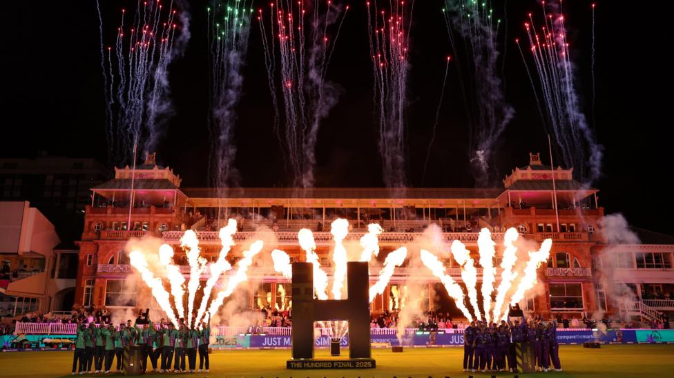 Celebrations for the two victorious Hundred teams at Lords for the 2025 finals of the Hundred. Oval Invincibles men stand on the left and Northern Superchargers women stand on the right. There is a big gold 'H' between then, and the backdrop is Lords pavilion at night, with fire and fireworks behind them in the sky. 