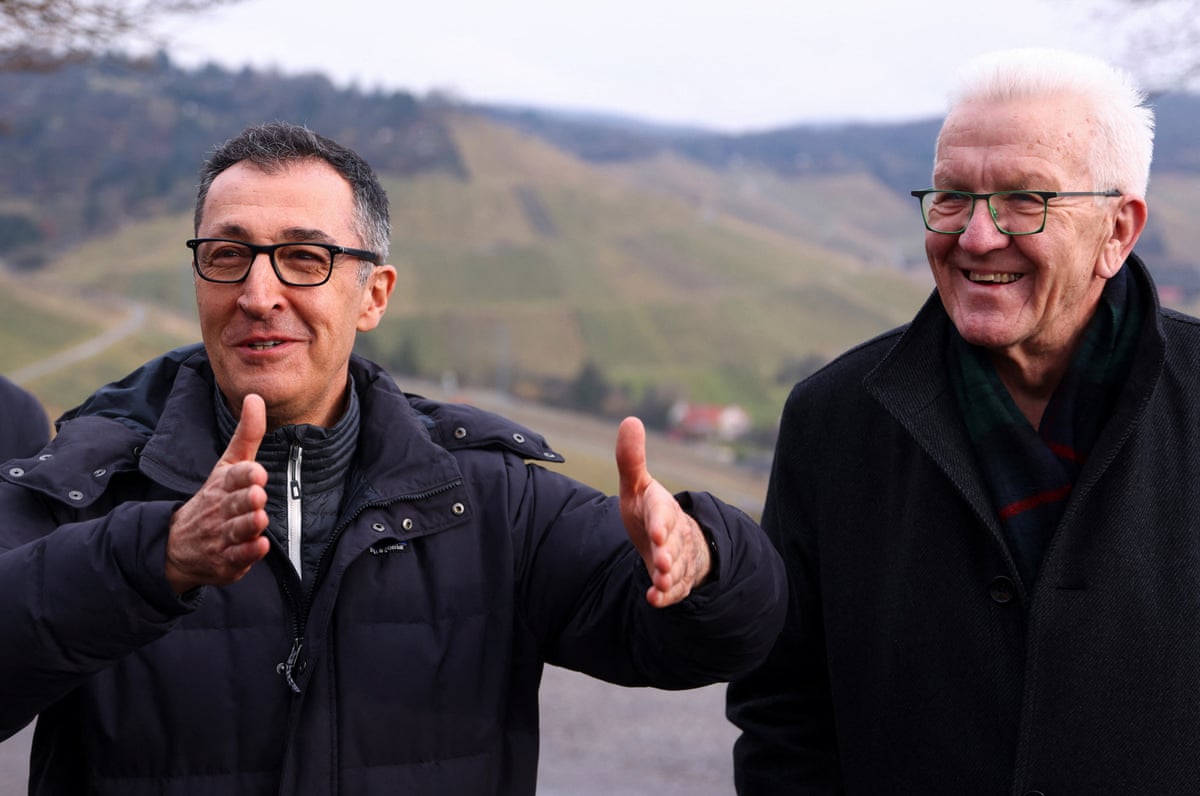 The two men smiling for a photo outdoors as Özdemir gestures with his hands