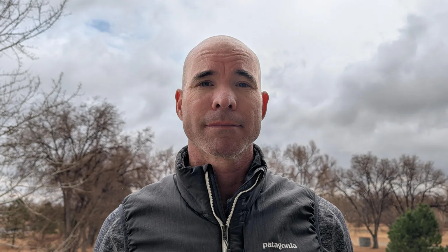 Zephr.xyz Bald-headed Sean Gorman wears a zip-up gilet with a grey jumper underneath.