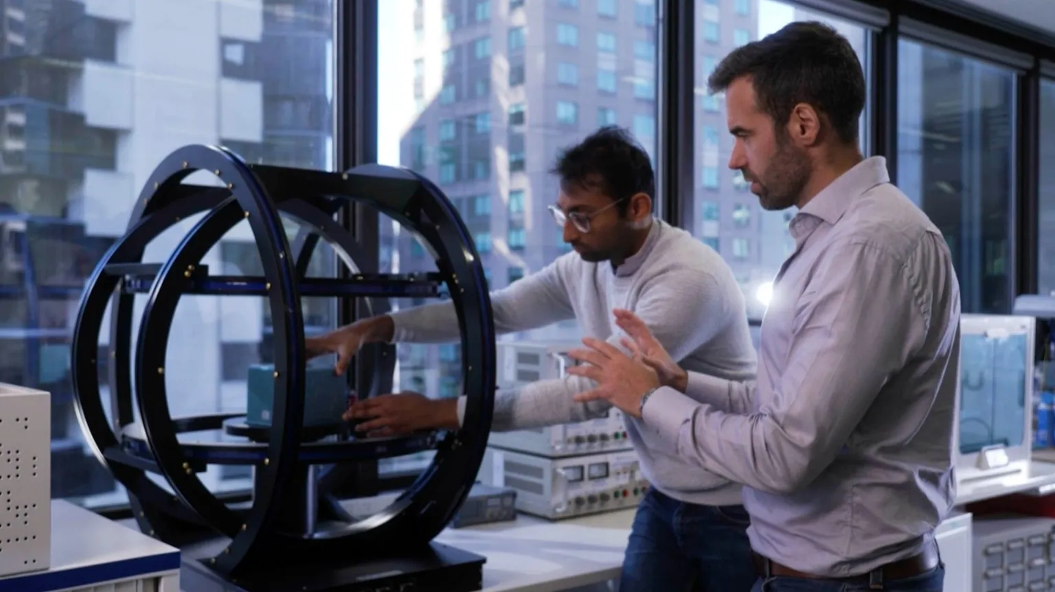 Advanced Navigation Two workers place a navigation device into a gyroscope.