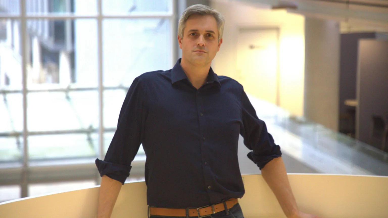 University of Southampton Prof Matthew Middleton posing for a photo inside a building. He is leaning against a railing.
