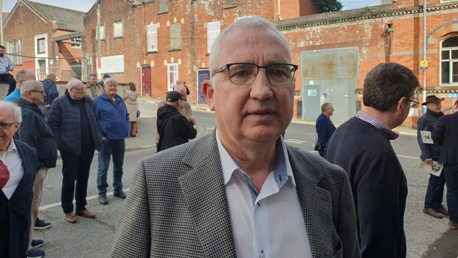 A man with a checked jacket, and blue shirt