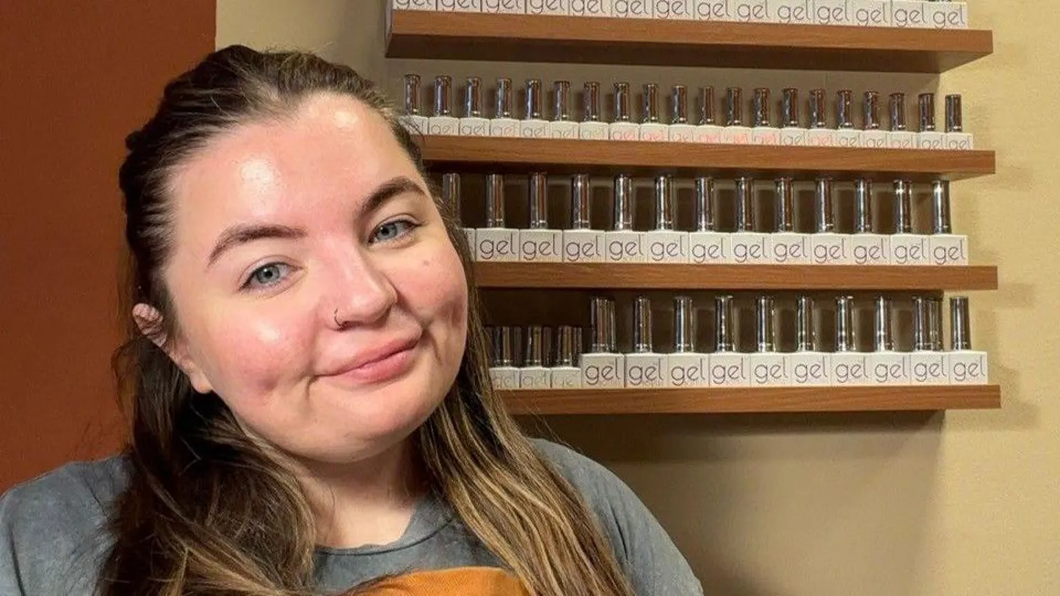 Emma Taff Emma has long brown hair and smiles in front of shelves of nail polish