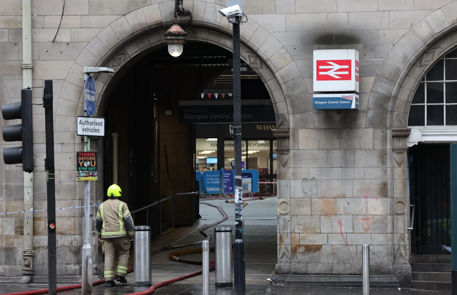  A firefighter by an entrance to the closed Glasgow Central railway station as work continues to dampen down the remains of a fire which broke out in a building adjacent to the railway station.