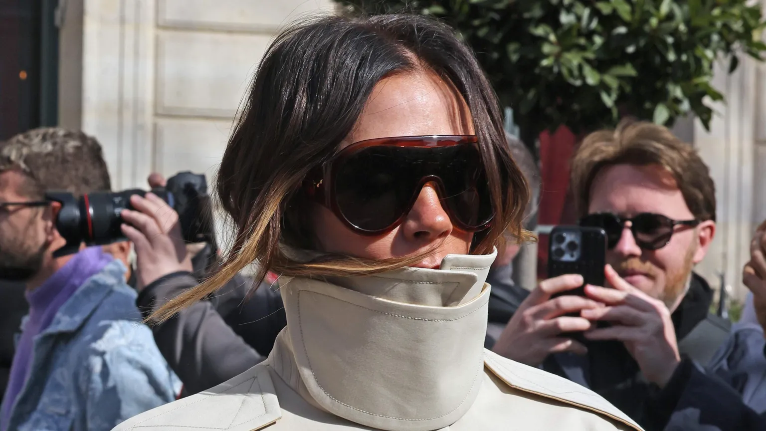  Victoria Beckham in a beige funnel-neck jacket and sunglasses leaving her hotel during Paris Fashion Week