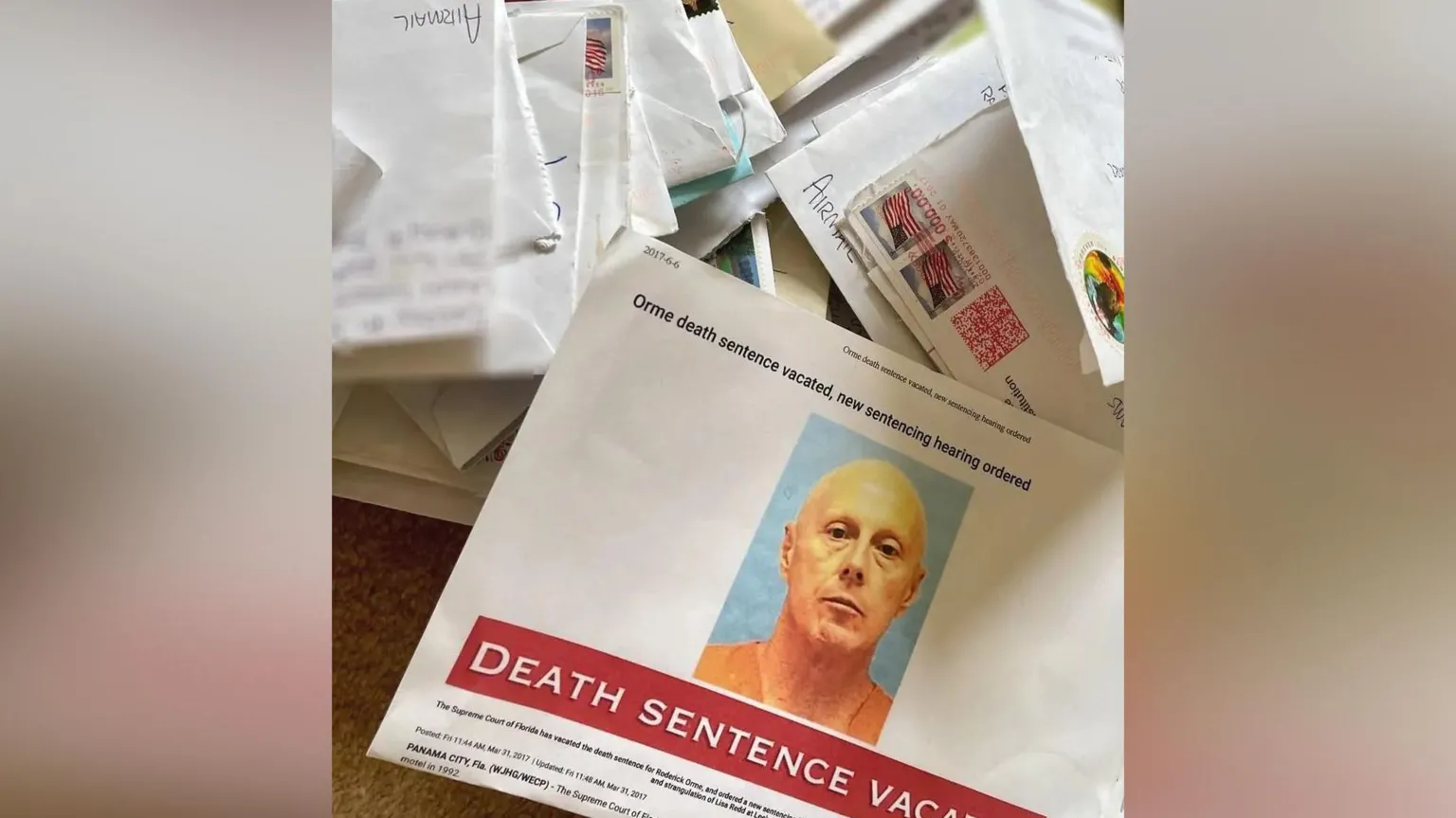 Rhys Williams A piece of paper bearing the mugshot of Orme wearing an orange jumpsuit. Letters can be seen in piles in the background.