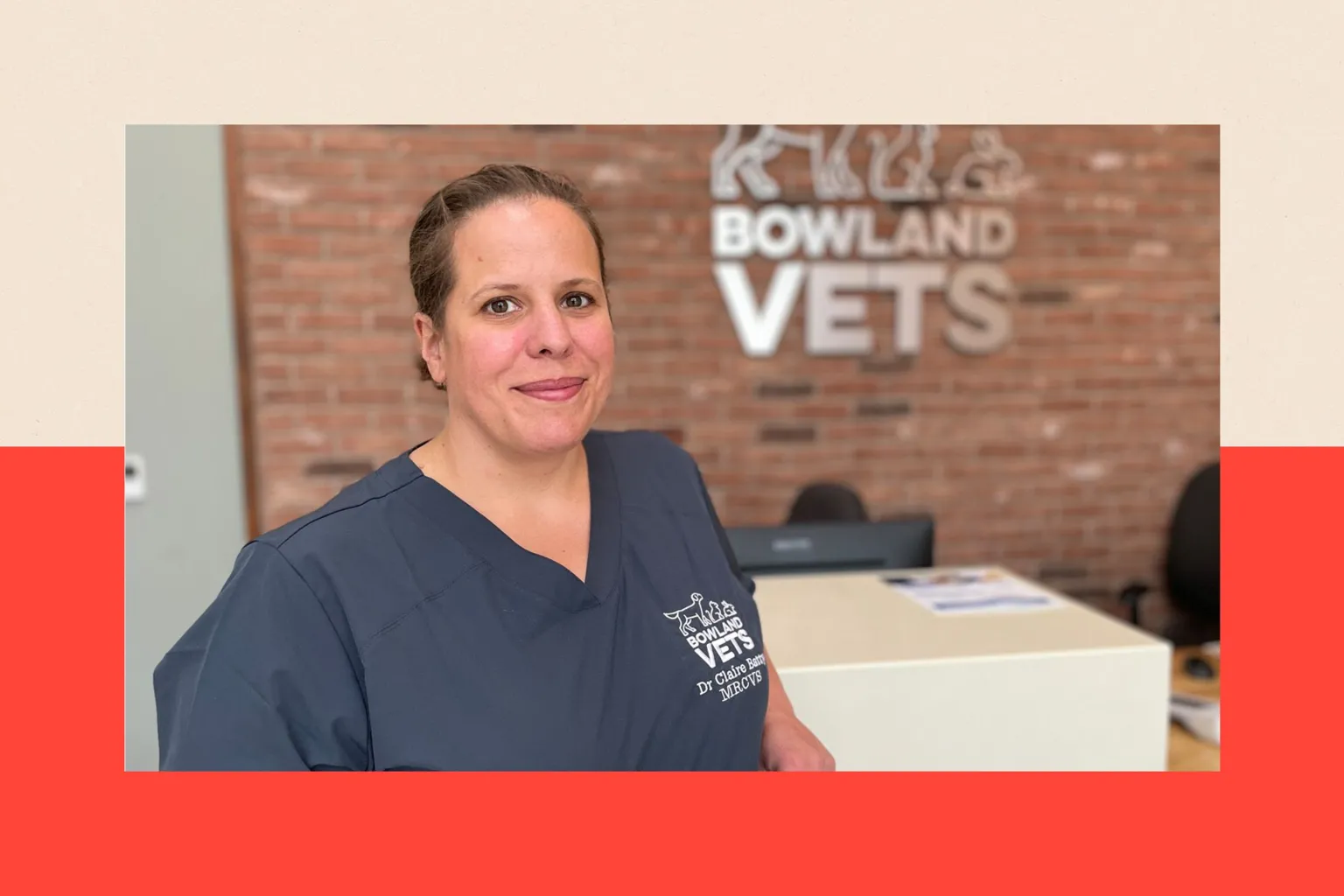 Claire Batty, wearing medical scrubs, standing in her surgery in front of a sign that reads Bowland Vets
