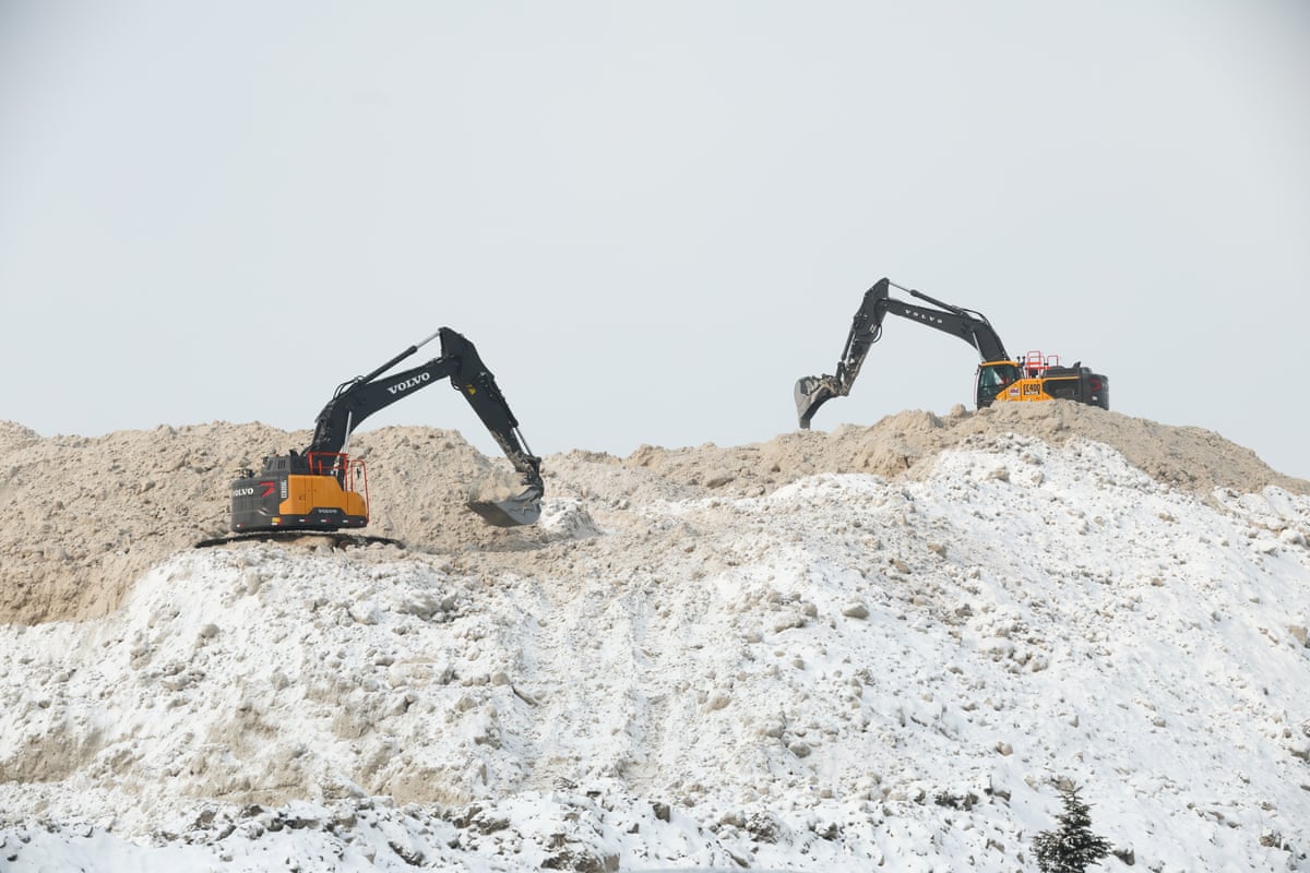 Power shovels scoop up large piles of snow in Toronto