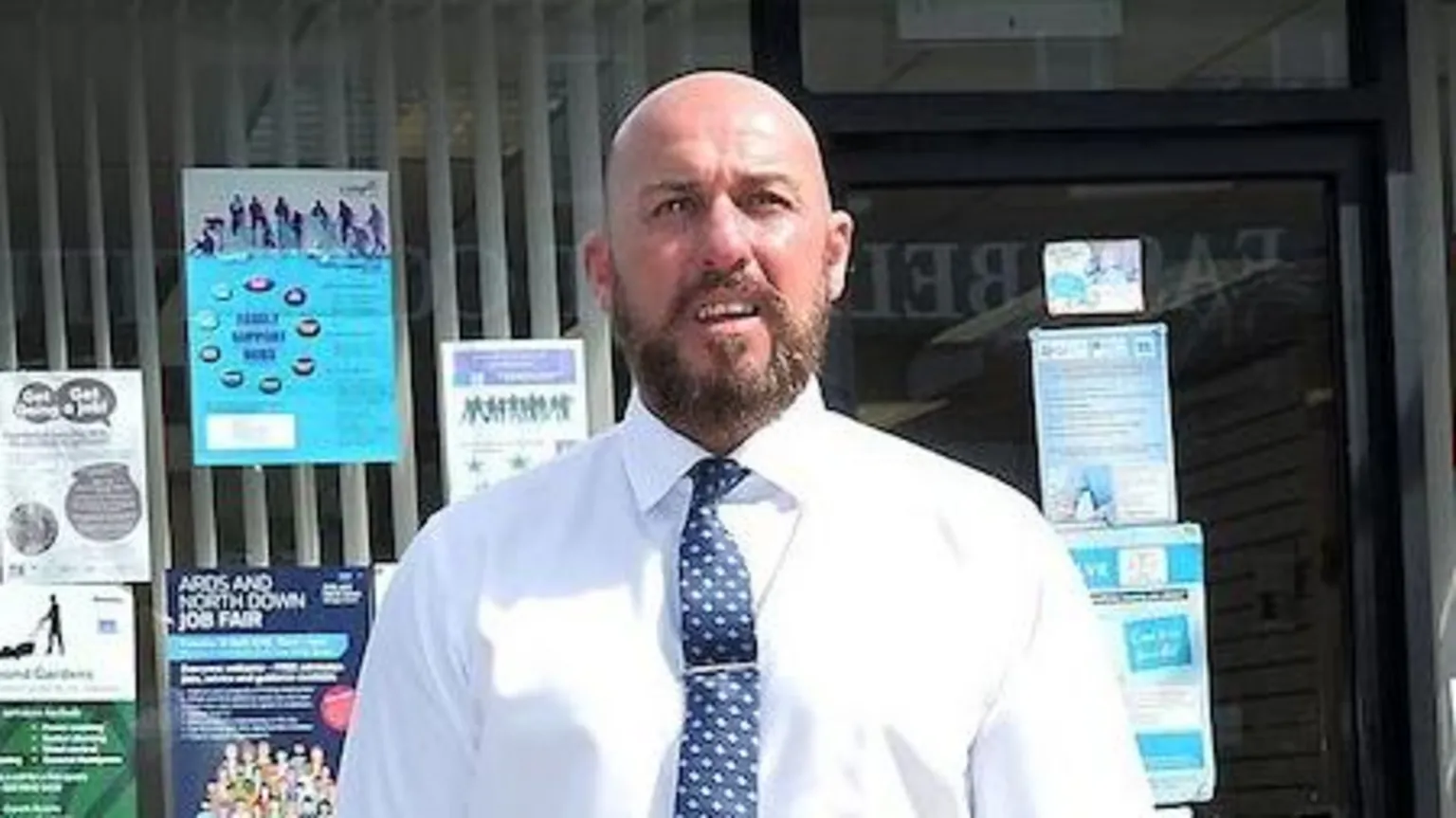 Pacemaker David Dee Stitt in a suit and tie stand outside an office