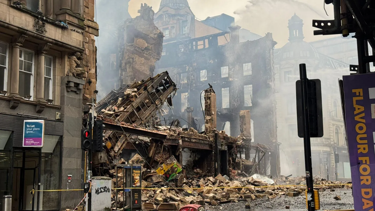 Network Rail The Union Corner building is reduced to rubble after a fire in Glasgow. Victorian buildings and street furniture surround the iron and sandstone remains. 