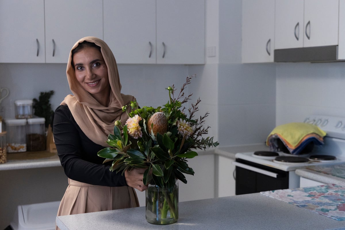 Tooba Sarwari in a kitchen behind a vase of flowers
