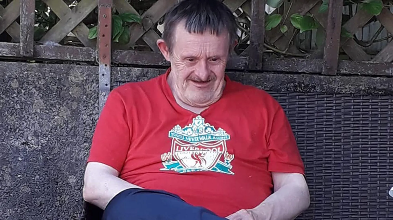 Athena Picture Agency Photo of William John Jones who had Down's syndrome. He had brown hair and is pictured wearing a red Liverpool football top and blue trousers.