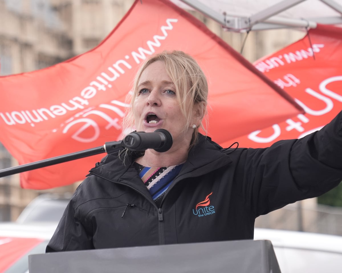 Sharon Graham making a speech with Unite flags in the background