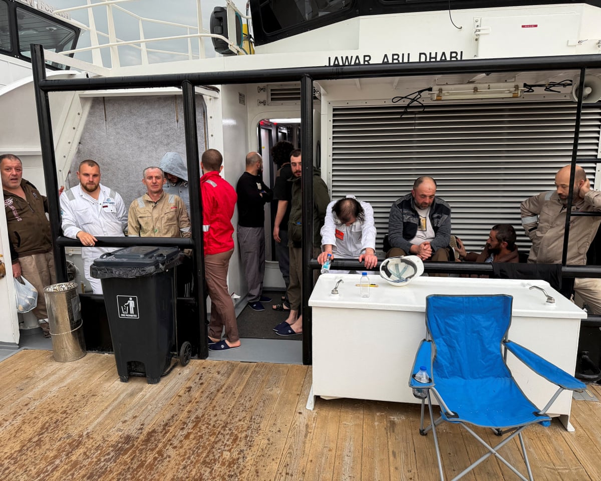 Crew members rescued from the fuel tanker Zephyros stand aboard an Iraqi vessel after the tanker was set ablaze in an apparent attack in Iraqi waters, at the Iraqi port of Faw