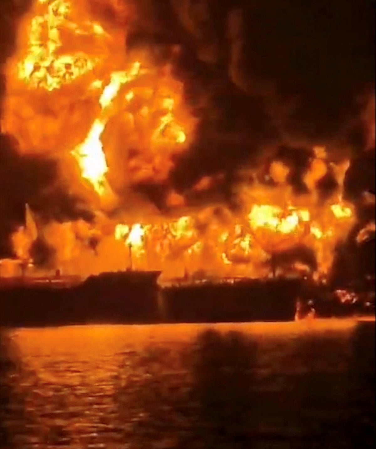 A ship burns after Iranian explosive-laden boats appear to have attacked two fuel tankers in Iraqi waters