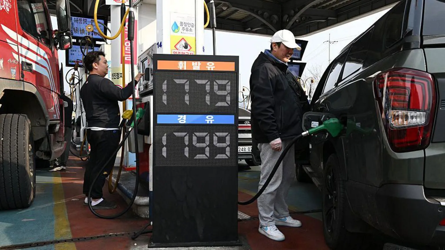  People fill up their cars at a petrol station in Seoul 