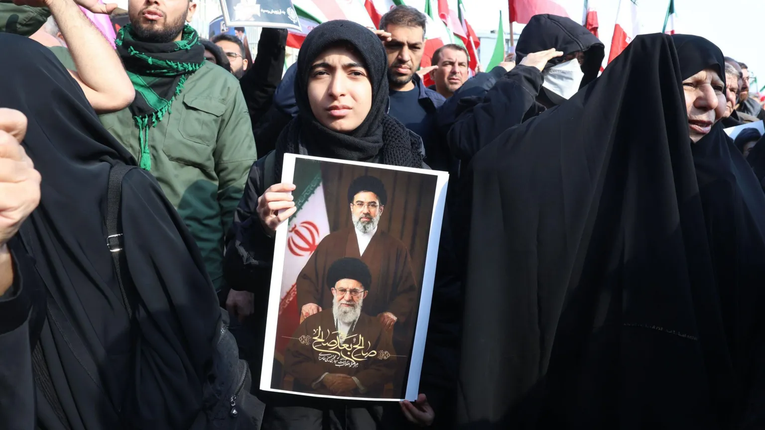 EPA An Iranian woman holds a picture featuring the late Iranian Supreme Leader Ayatollah Ali Khamenei (down) and the newly appointed Supreme Leader Ayatollah Mojtaba Khamenei (down) during a gathering in support of the newly appointed Supreme Leader in Tehran, Iran, 09 March 2026