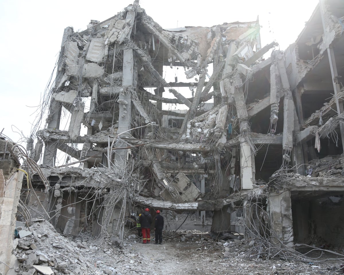 People at damaged buildings in Tehran, Iran, on Thursday