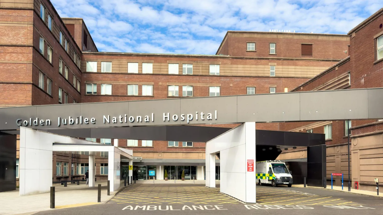 Exterior of Golden Jubilee National Hospital. An ambulance is parked outside a modern five-storey building.