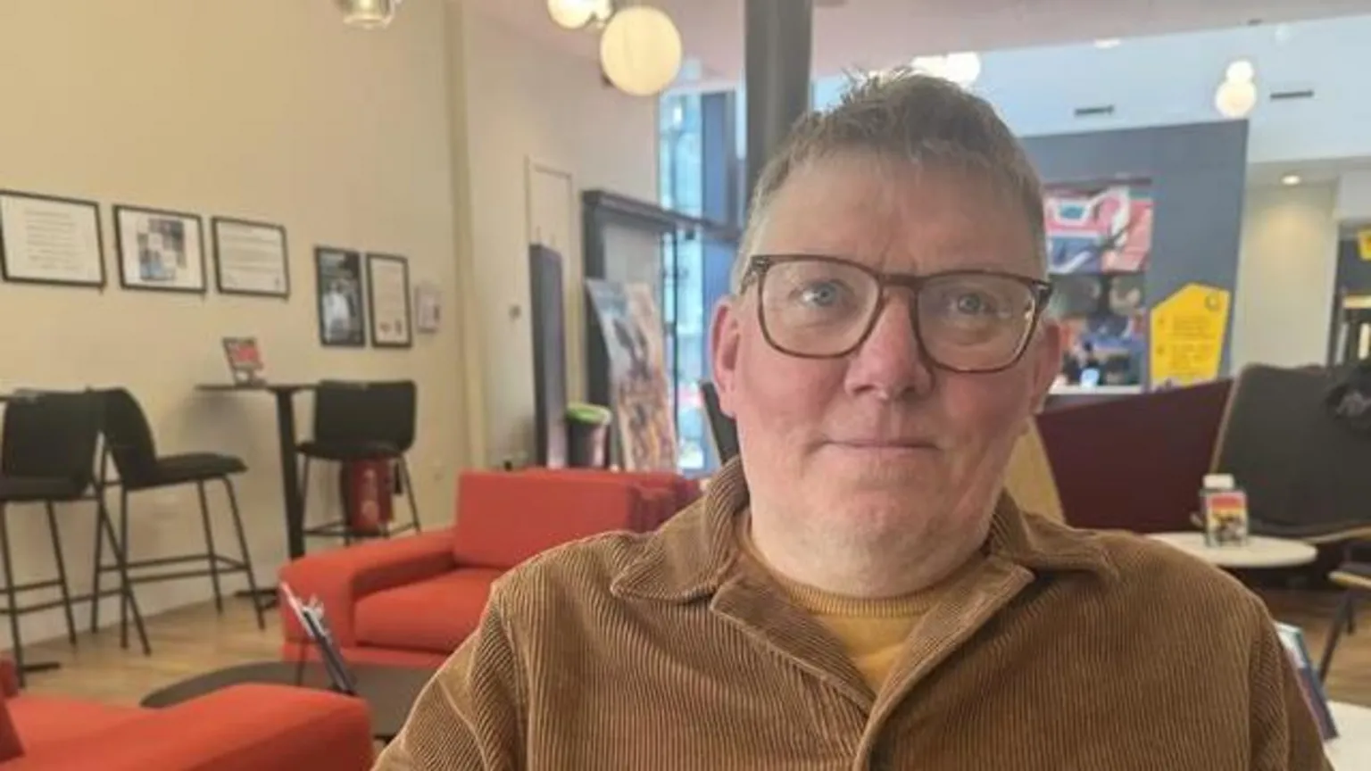 A man sat inside the Phoenix Cinema foyer