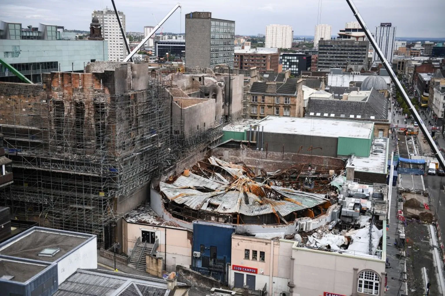 A view of Glasgow from the rooftops. Two fire damaged buildings in the foreground - the circular ABC with its roof caved in and the blackened school of art.