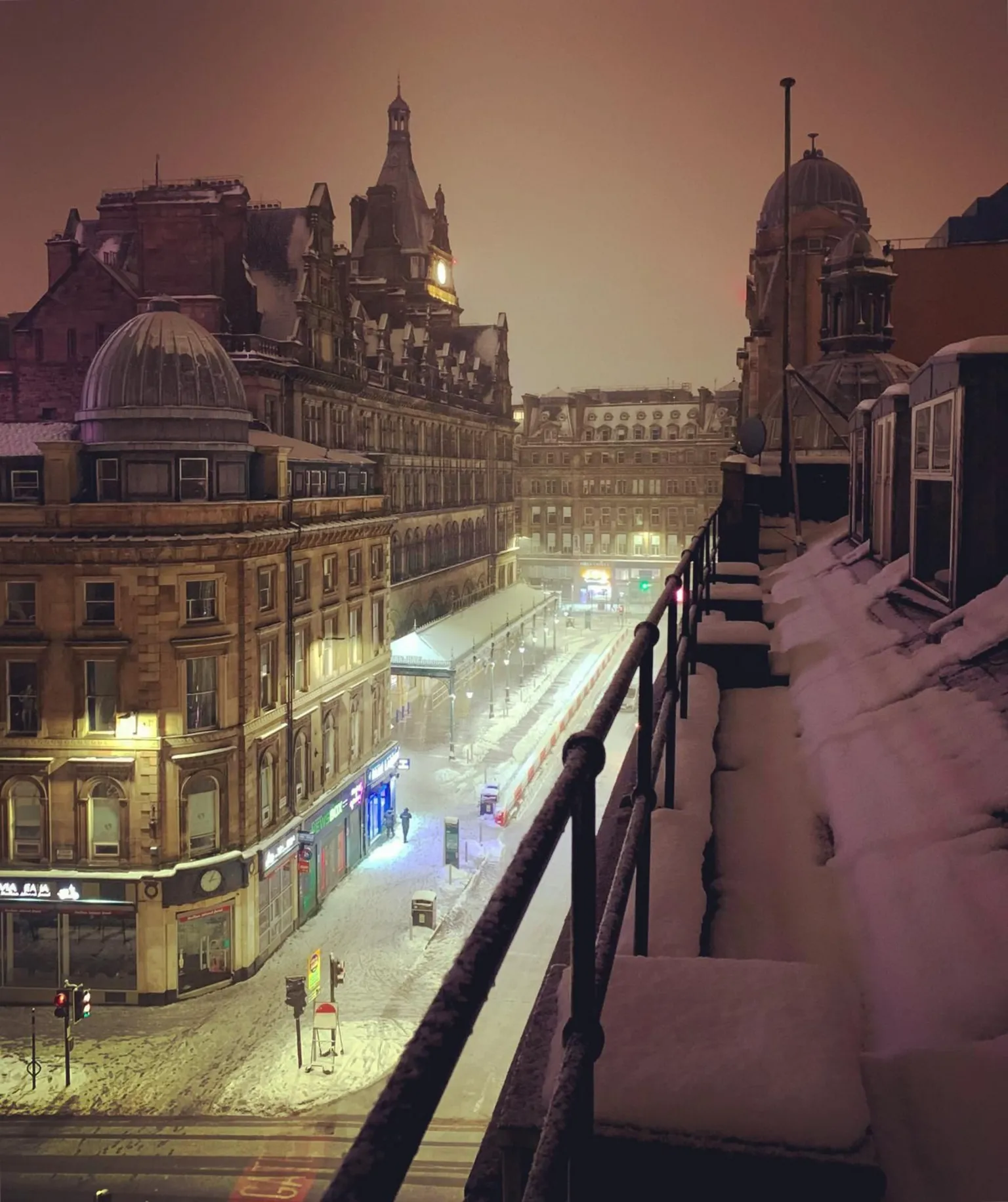 Michelle Cohen Streetlights illuminating the snow on Gordon Street in Glasgow. Central Station is in the background. The dome of the Union corner building is visible in the foreground.
