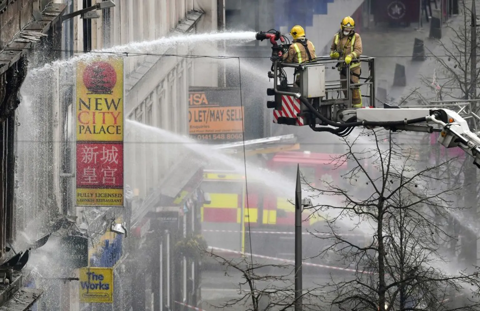 Firefighters aiming water cannons at a building on Sauchiehall Street from a height