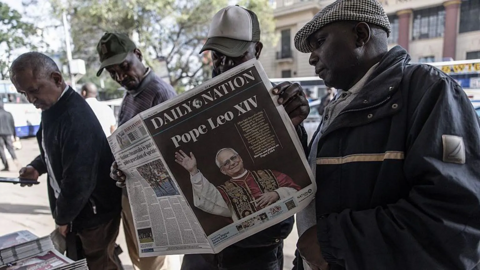AFP via A group of men at a news stand with one of them holding up the Daily Nation. The headline is about Pope Leo XIV.