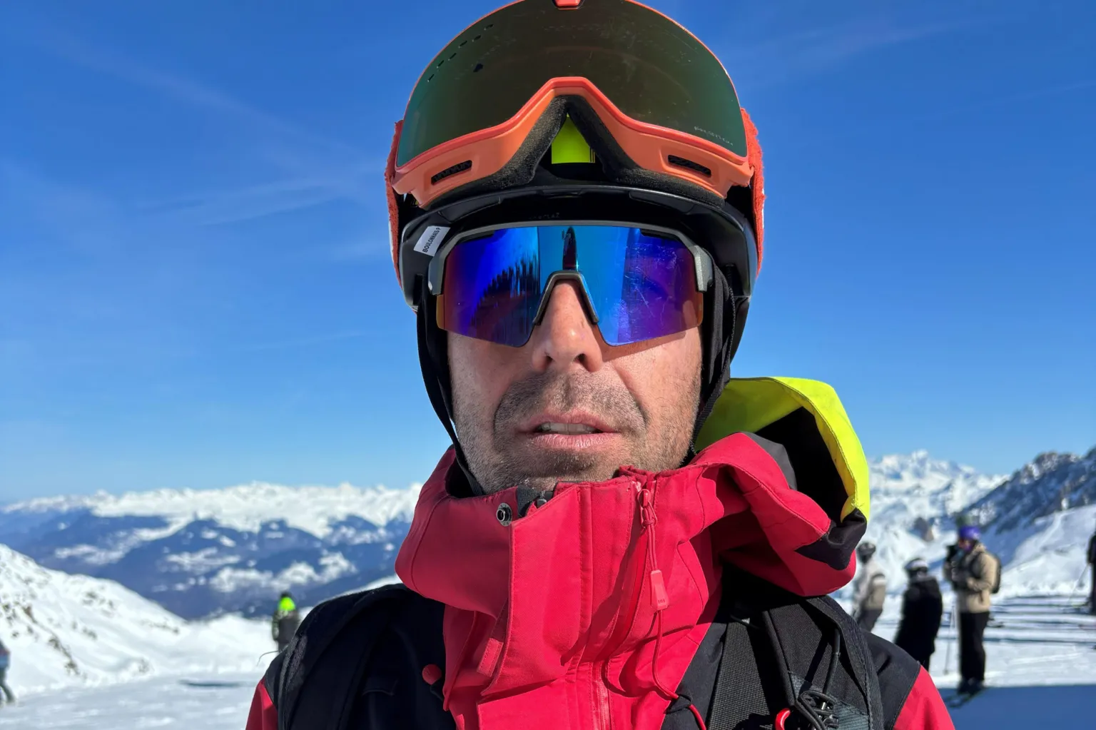 BBC/Paul Pradier A man wearing a red jacket and sunglasses and a ski helmet is seen in front of a snowy landscape