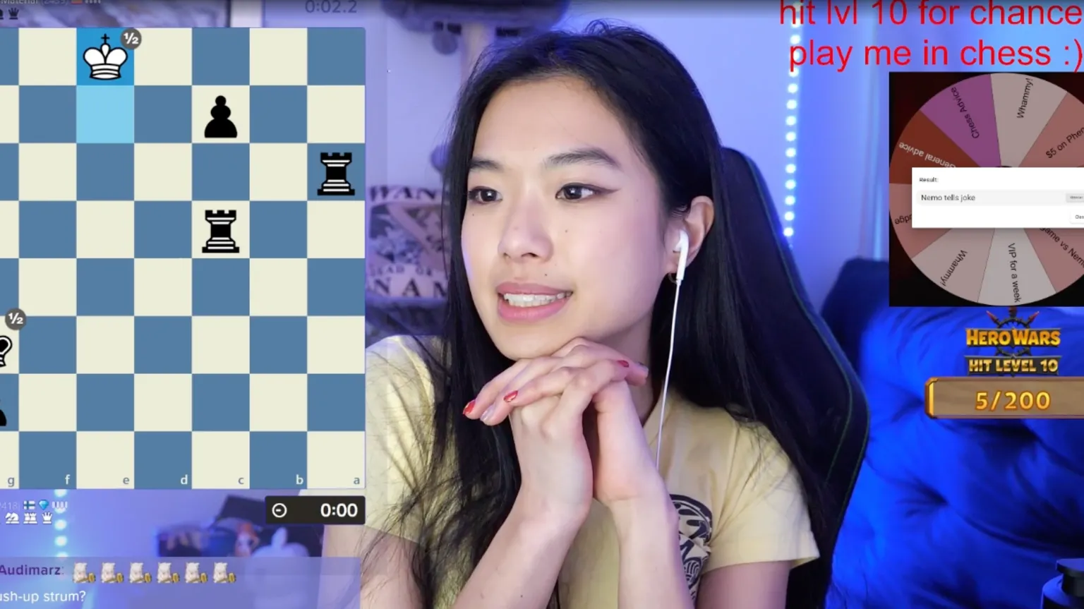 Courtesy Nemo Zhou via Twitch Screen shot of Nemo playing chess on Twitch. She is in the centre of the image, a chess board is visible on her left. On the right is a wheel of fortune and letters saying 'hit lvl 10 for chance play me in chess :)'. Her background is blue because of neon lightning. 