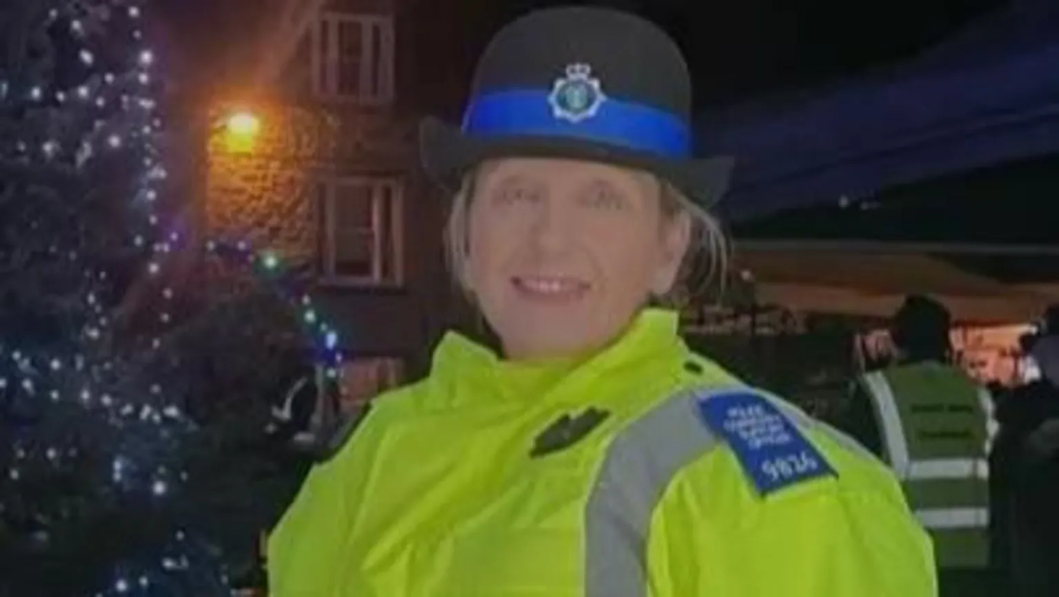 Handout Joanne Donohoe in her high visibility police uniform, with a black and blue police hat, stood in the street beside a Christmas tree.