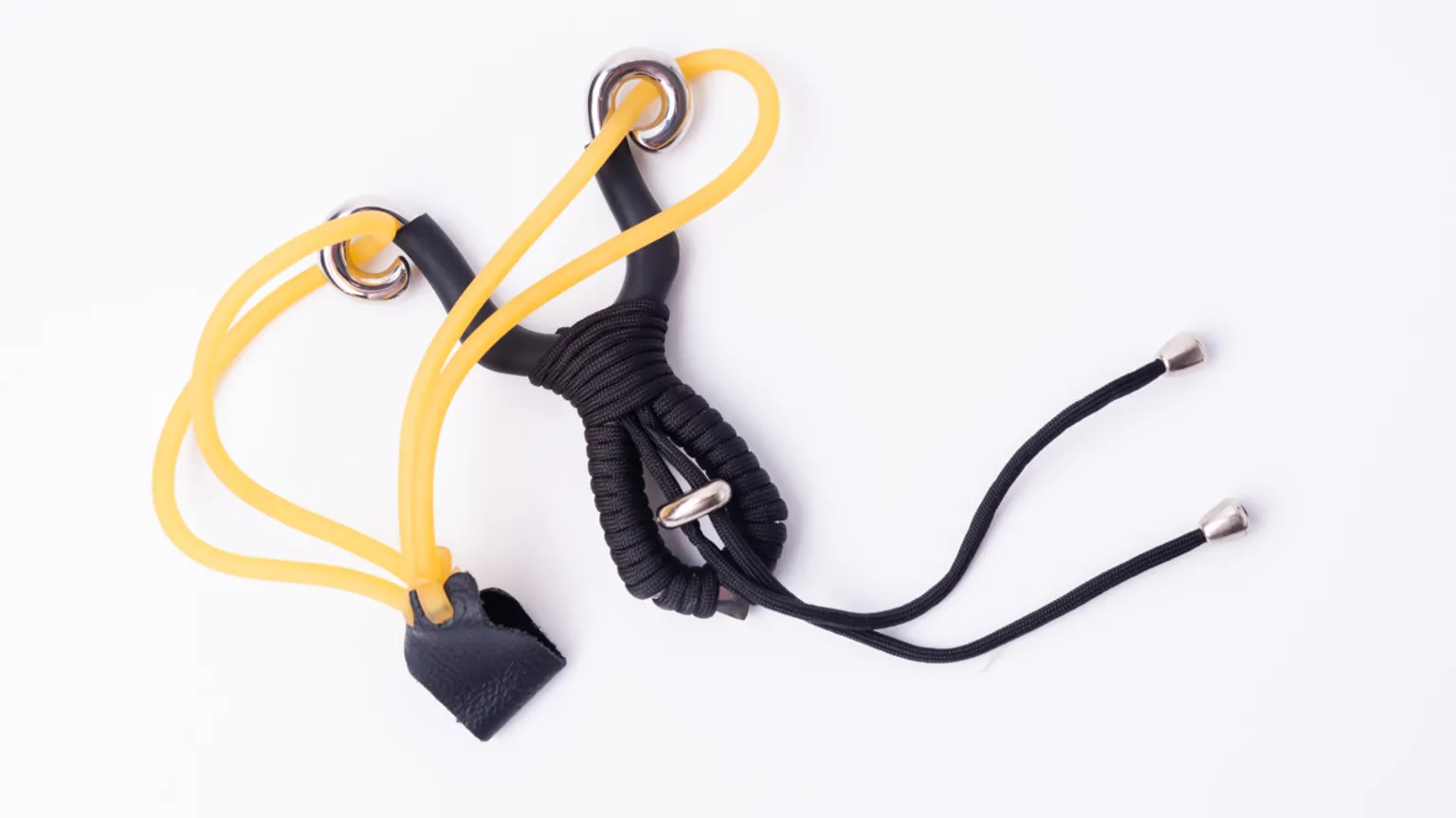  A black and yellow catapult lying on a plain white surface.