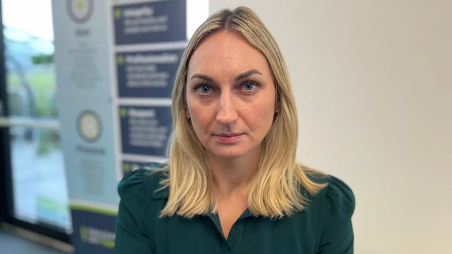 A woman with blonde hair in a green shirt.
