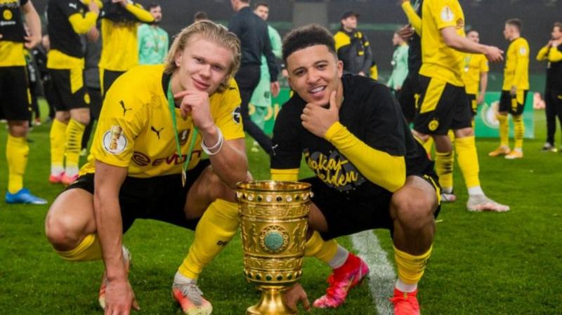 Erling Haaland and Jadon Sancho pose with the German Cup after Borussia Dortmund's triumph in 2021
