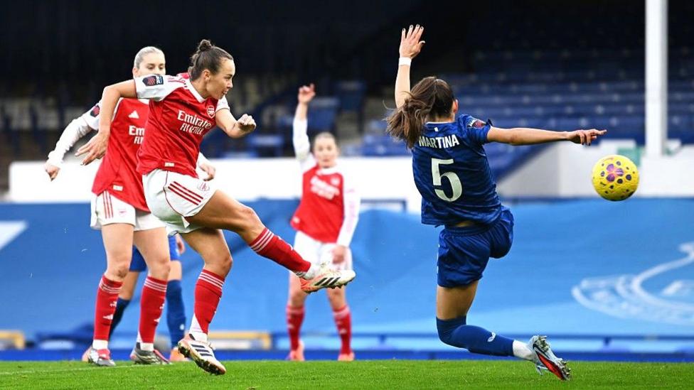 An Arsenal player strikes at goal in front of empty seats at Goodison Park